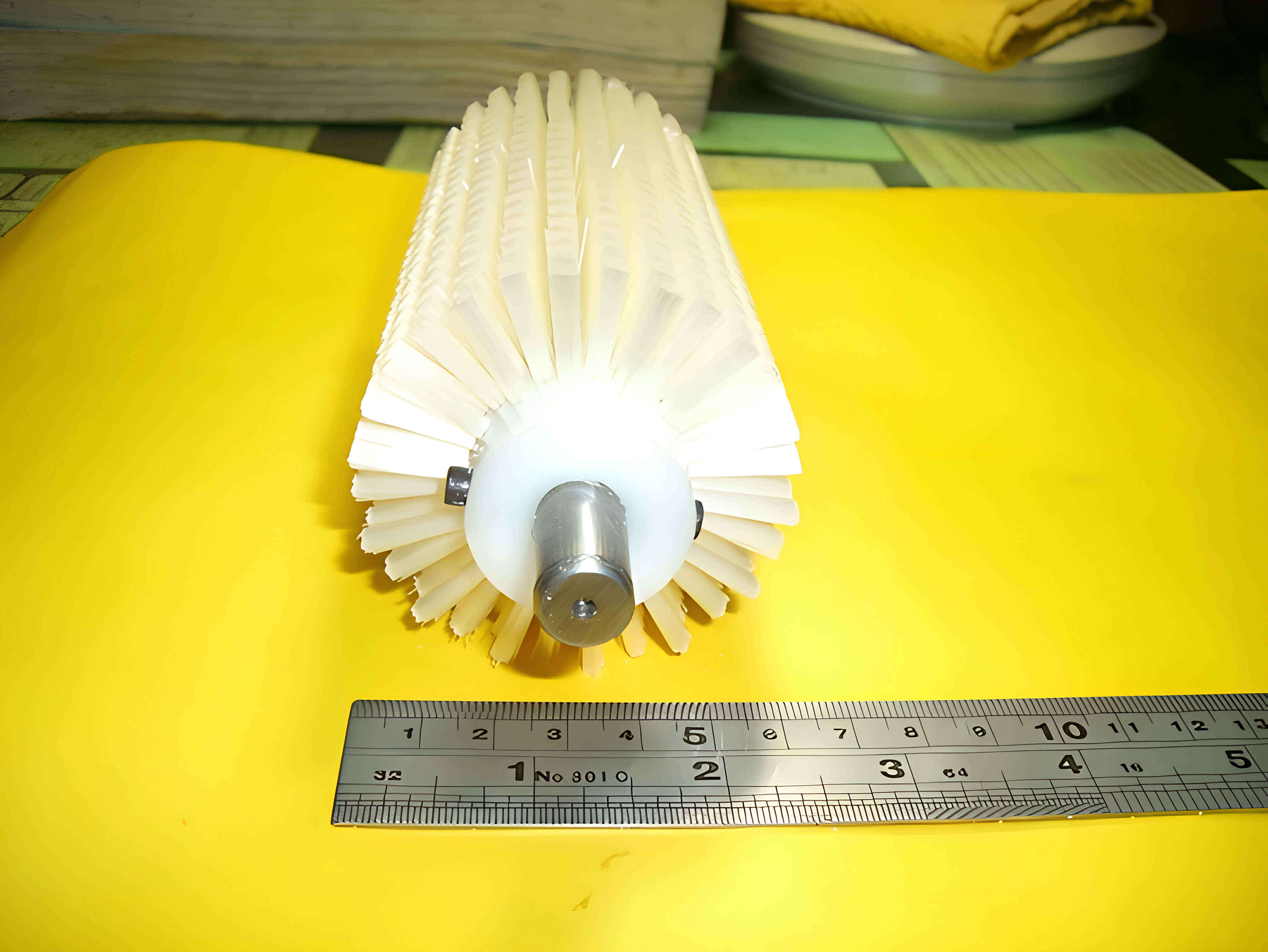 An actual YC Brushes roller brush, showing the metal shaft running through the brush core